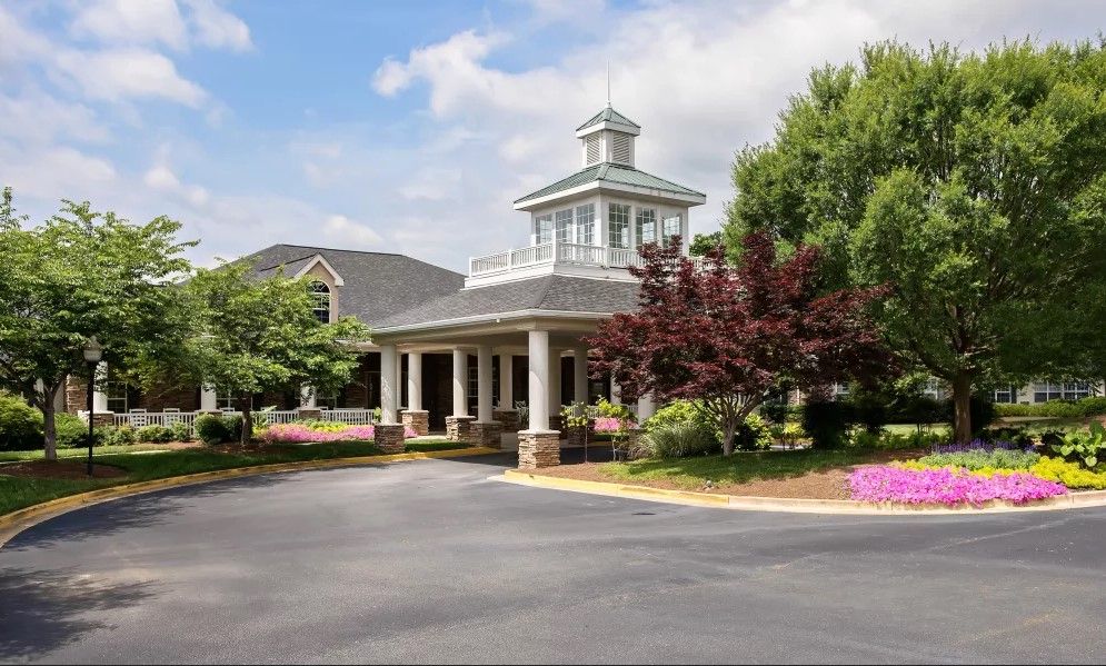 A scenic view of a building entrance surrounded by trees and landscaping.