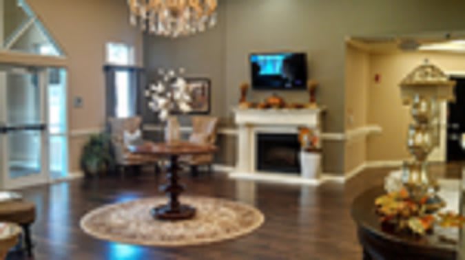 An elegantly decorated living room with a chandelier, fireplace, and television.