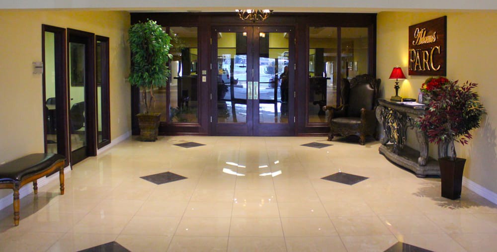 A spacious lobby entrance with glass doors, decorative plants, and comfortable seating.