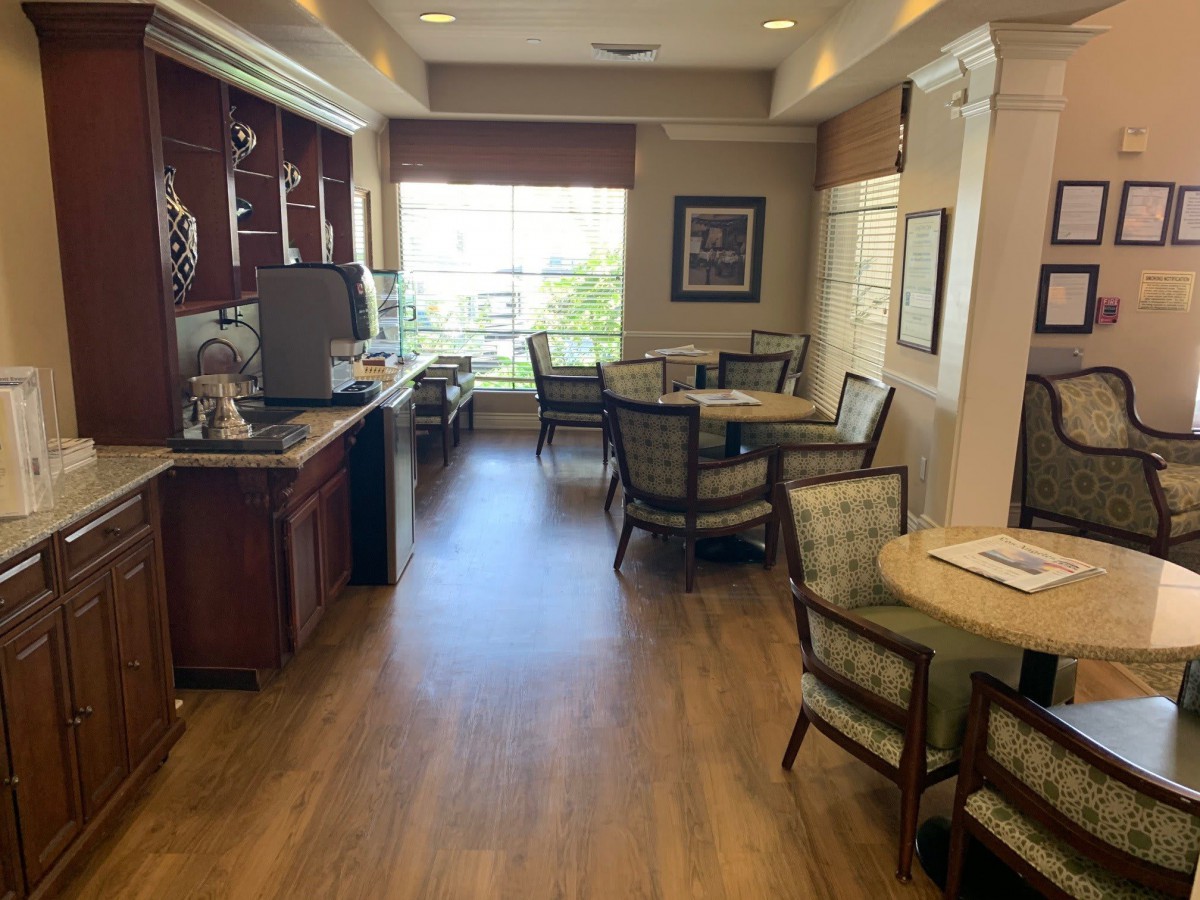 A cozy cafe seating area with tables, chairs, and a coffee station.