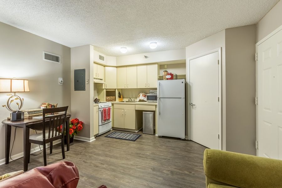 A cozy apartment kitchen with modern furnishings and a small dining area.