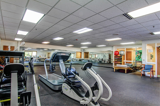 A well-equipped gym featuring various exercise machines and a spacious workout area.