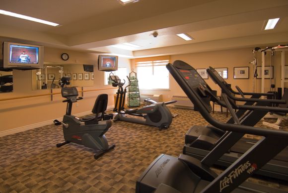 A gym room featuring treadmills and stationary bikes for fitness enthusiasts.