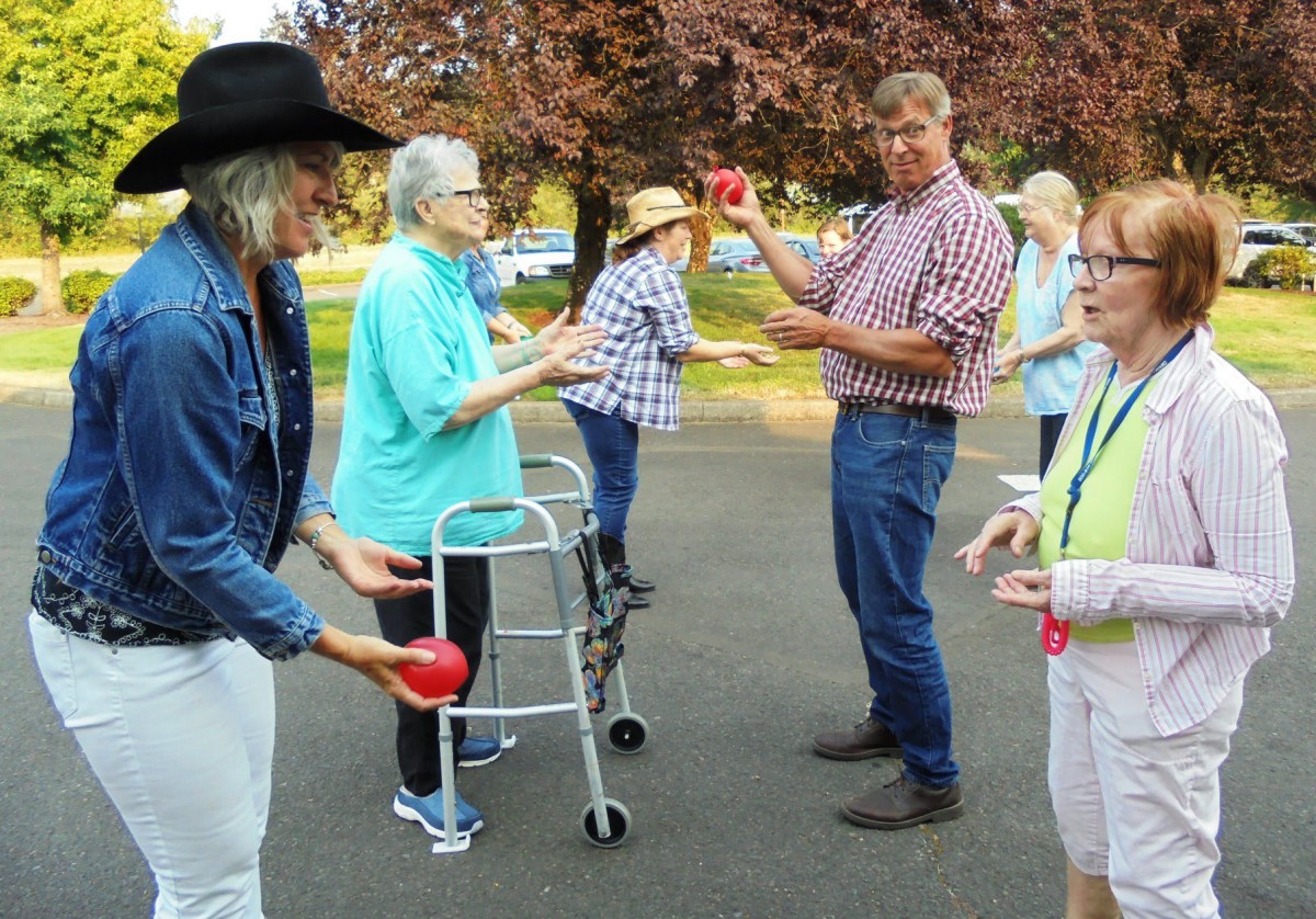 A group of people participating in an outdoor activity, engaging in conversation and exercise.