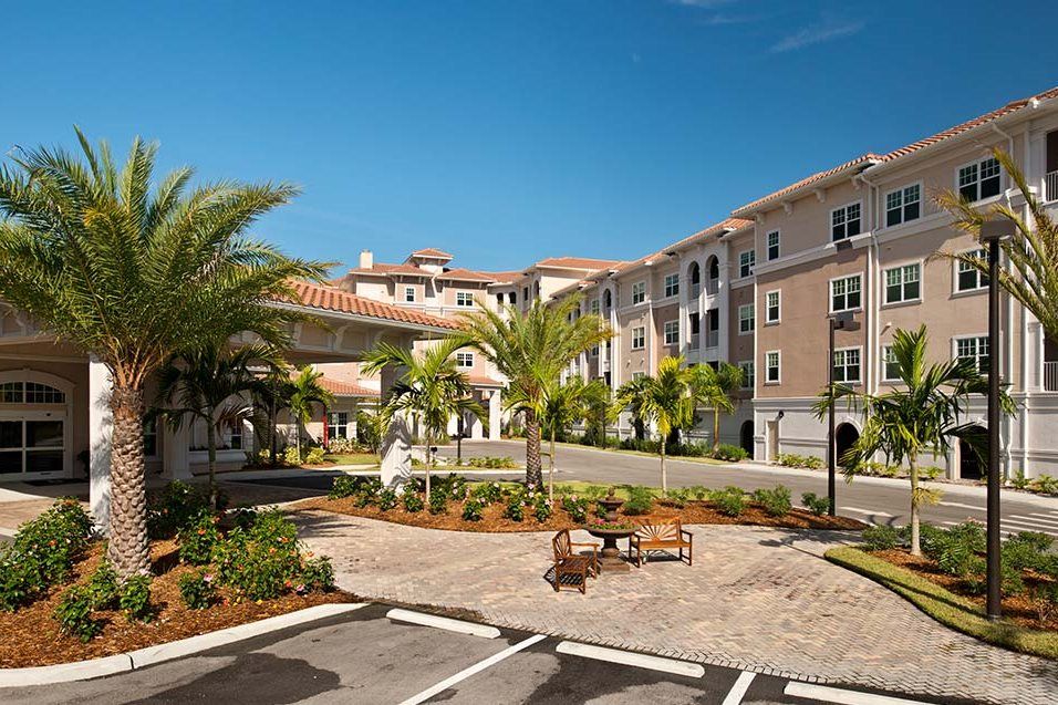 A sunny day at a residential complex with palm trees and well-maintained landscaping.