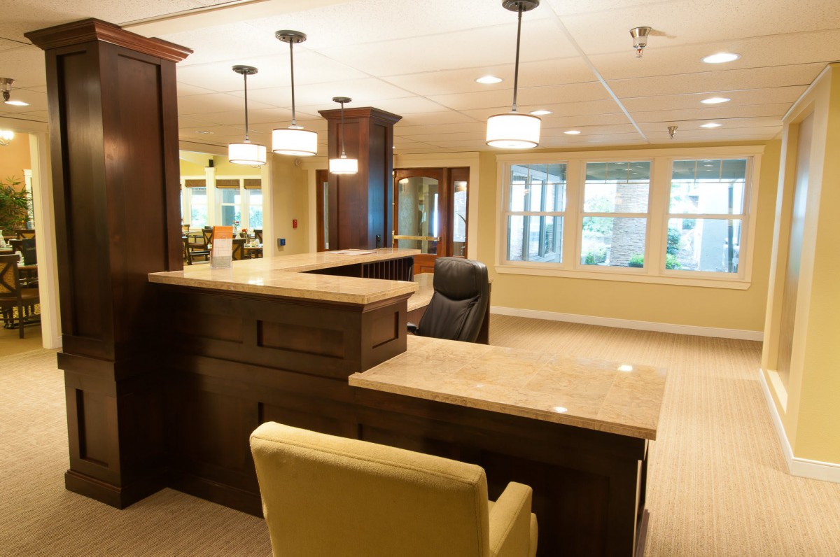 A well-lit reception area featuring a large desk and comfortable seating.