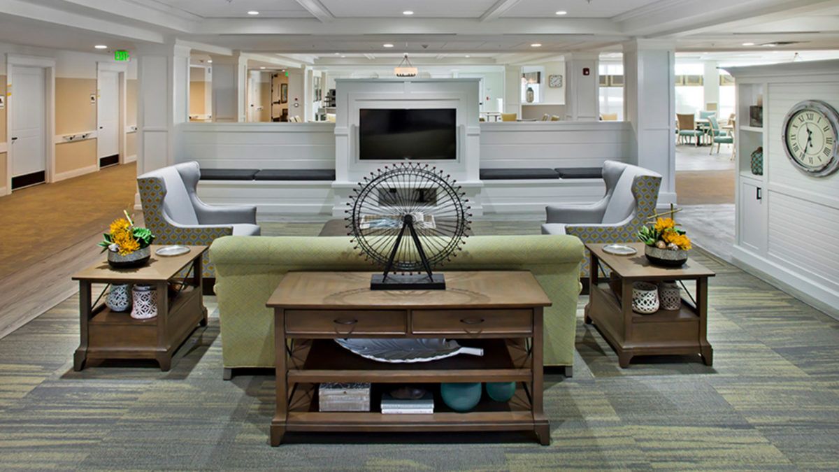 A modern living room with a central TV, sofas, and decorative elements.