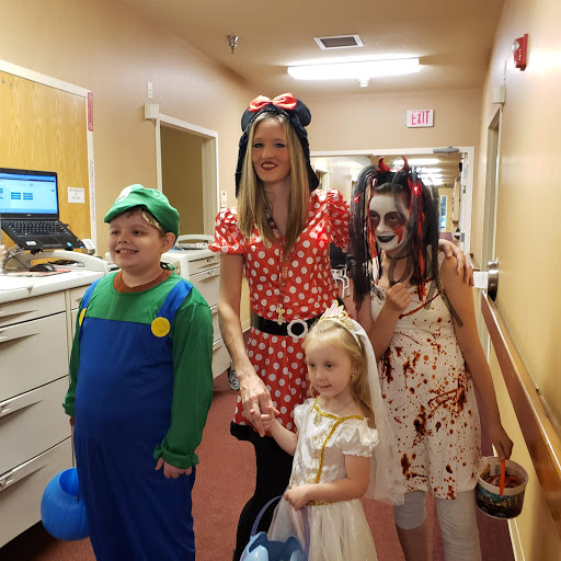A group of children and an adult dressed in festive costumes, ready for Halloween celebrations.