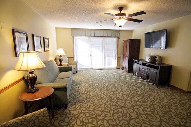 A spacious living room with modern furniture and a ceiling fan.