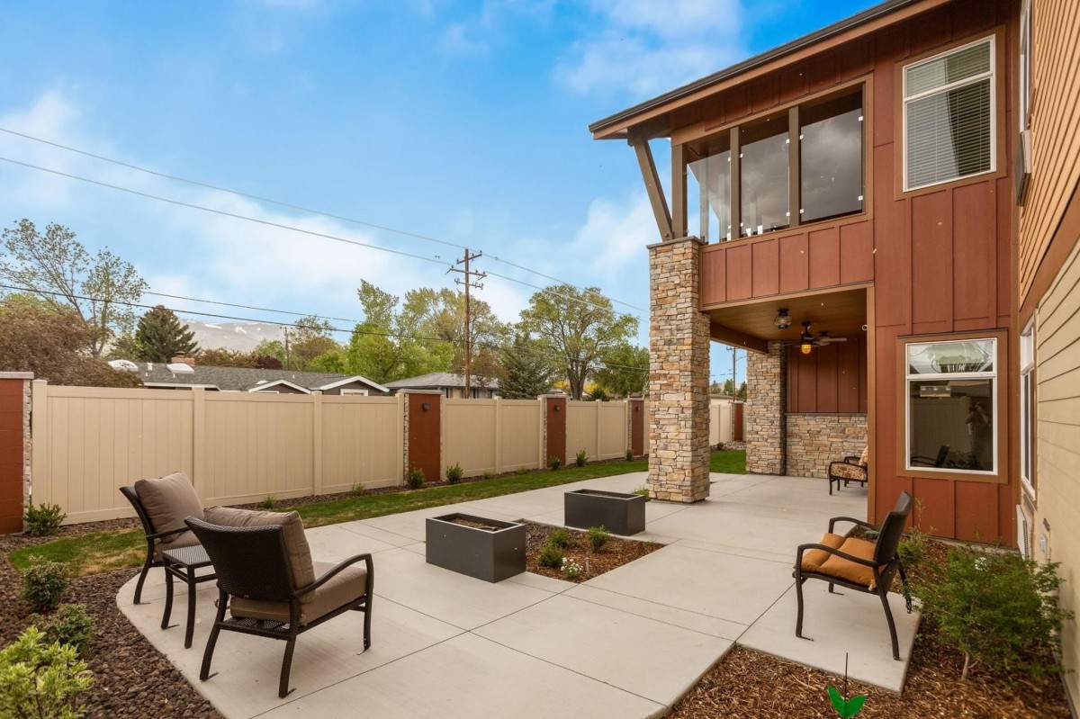 Modern backyard patio with outdoor seating and fire pit.