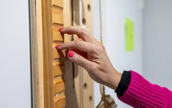A hand interacting with a textured wooden surface.