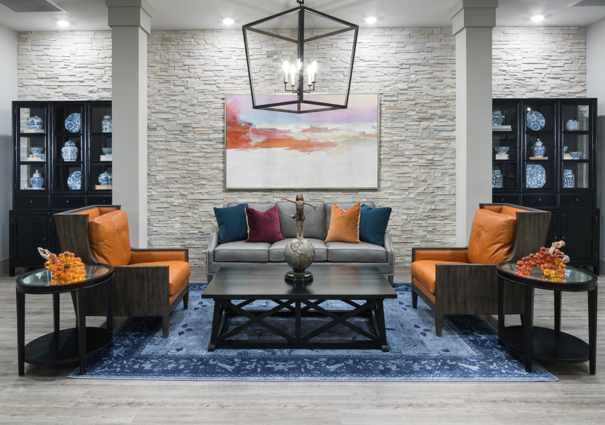 A modern living room with stylish furniture and a textured wall backdrop.