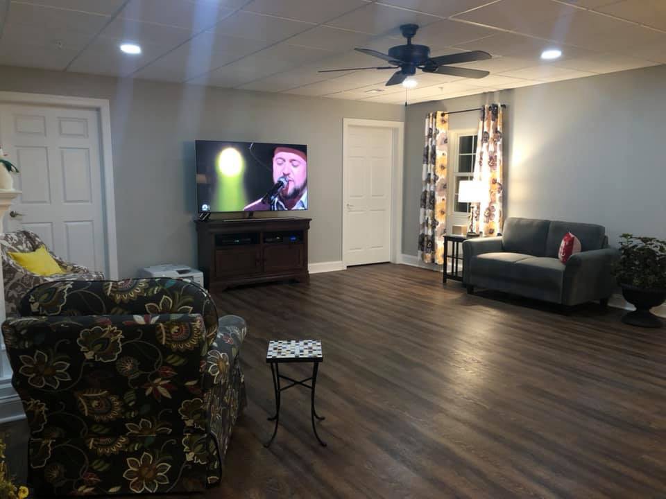 A cozy living room with a television, sofa, and hardwood floor.