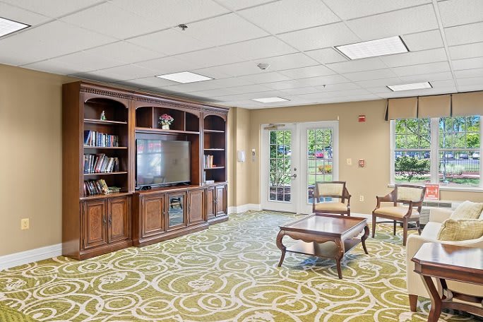 A cozy living room with a television, bookshelves, and comfortable seating.