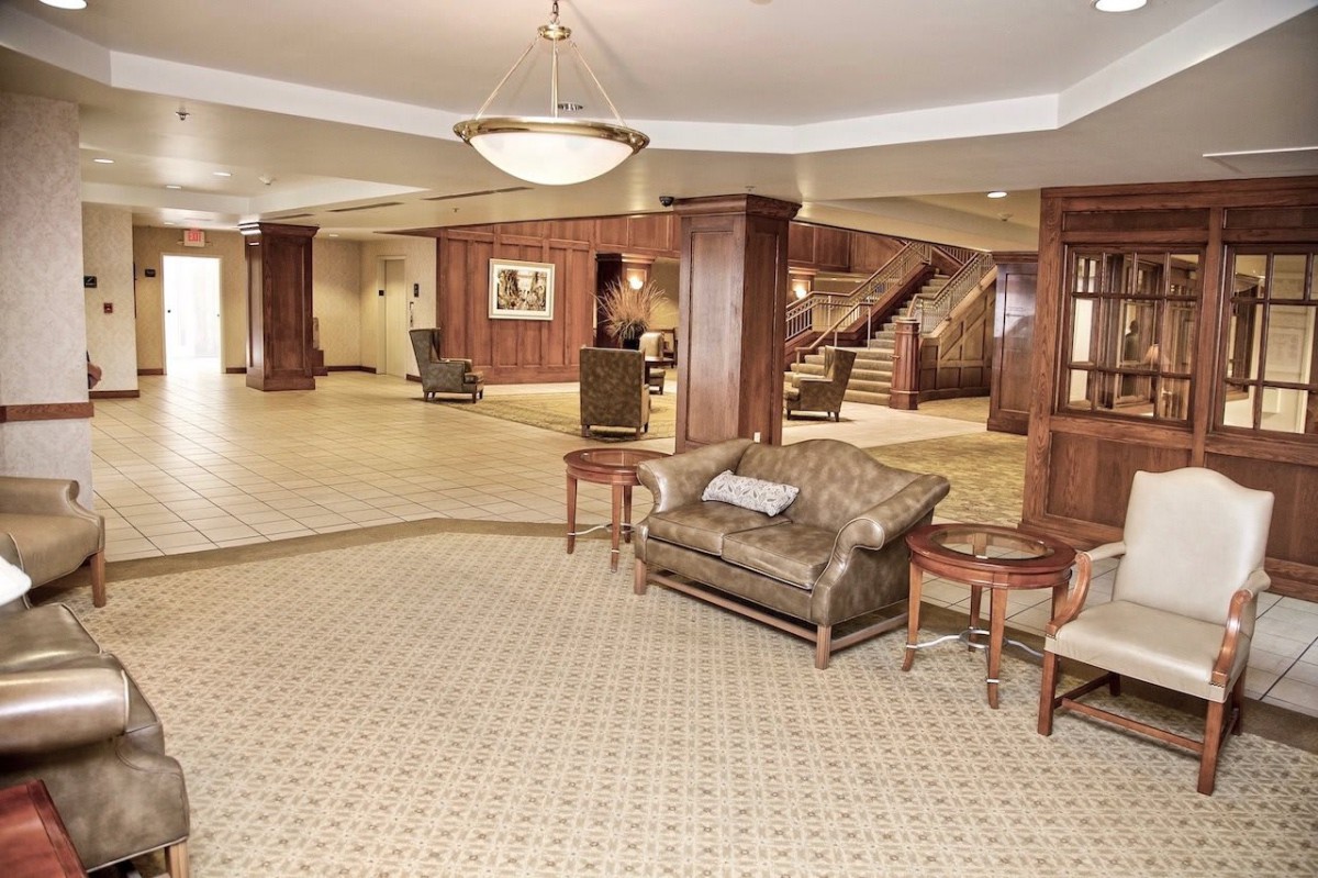 A spacious lobby with a seating area, featuring wooden paneling and elegant decor.