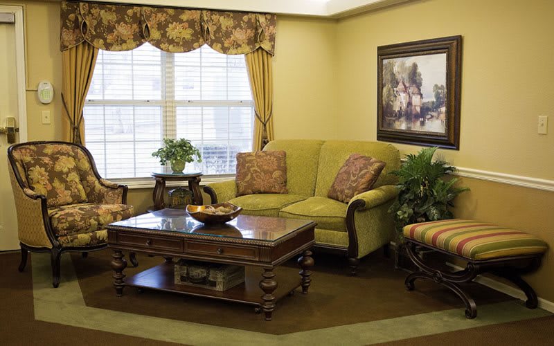A cozy living room with a plush sofa, armchairs, and a wooden coffee table surrounded by elegant decor.