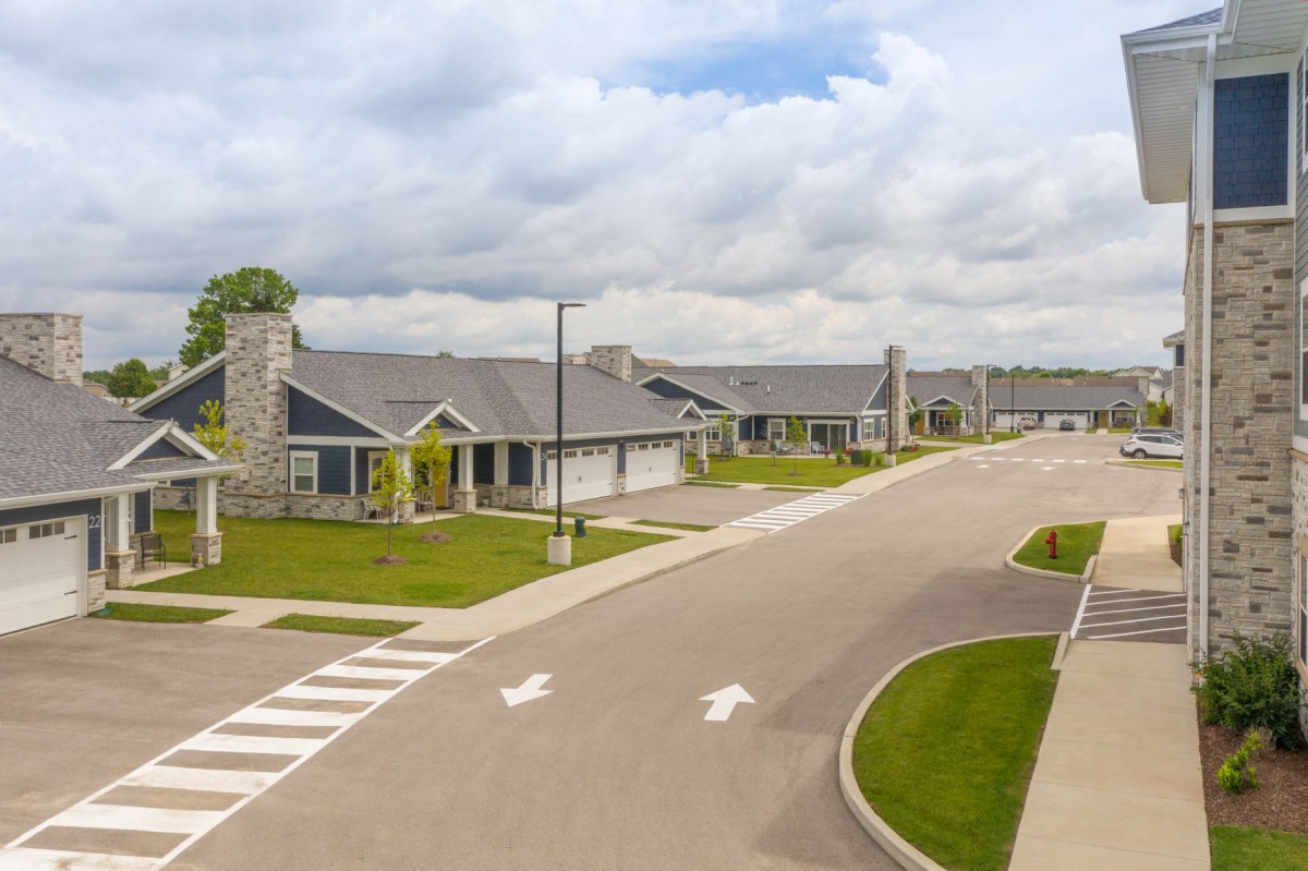 A quiet suburban neighborhood with newly built houses and a wide road.