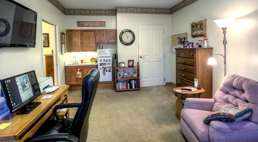 A cozy living area with a kitchenette, featuring furniture and decor.
