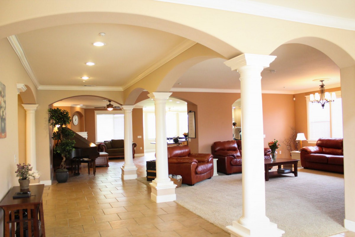 Spacious living area featuring elegant columns and comfortable furnishings.