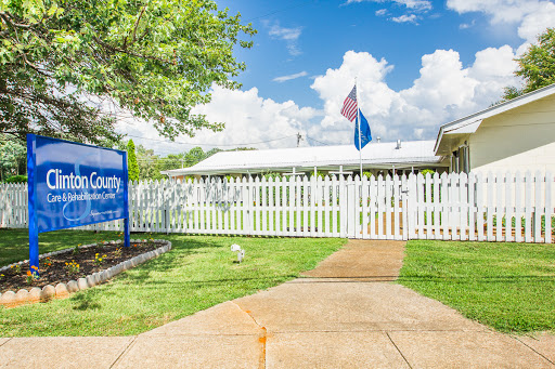 A welcoming community center with a white picket fence and flags waving under a bright blue sky.