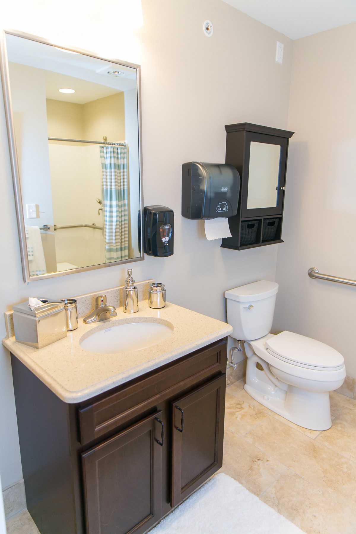 A clean and organized bathroom with a sink, toilet, mirror, and various fixtures.
