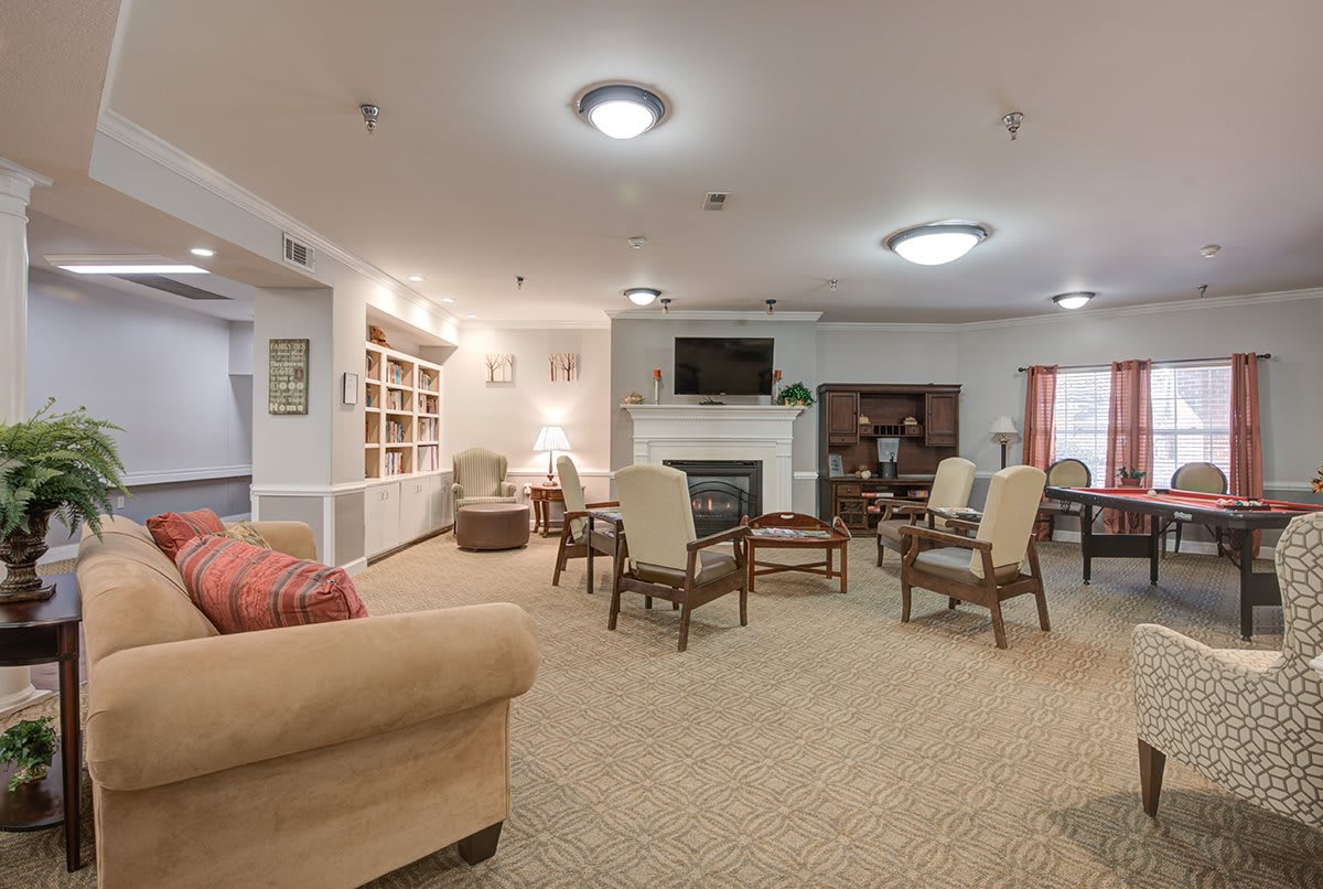 A cozy living room with seating area, bookshelves, and a fireplace.