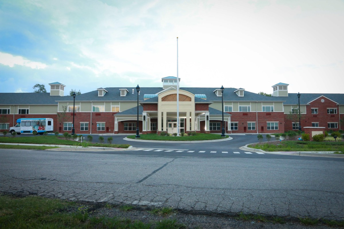 A large brick school building with a prominent entrance and multiple windows.