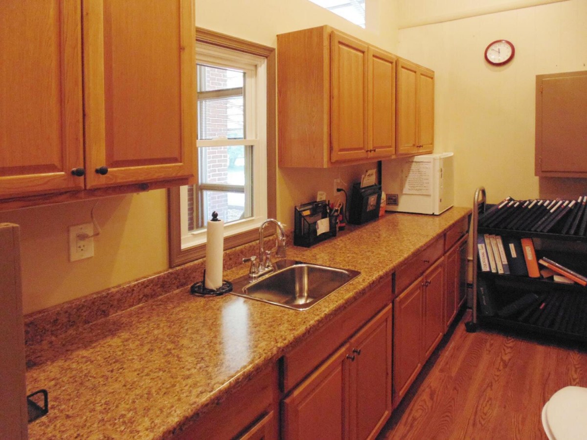 A kitchen featuring wooden cabinets and a granite countertop.