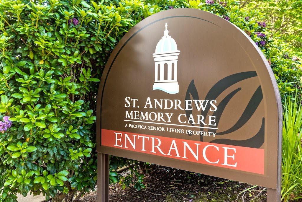 Sign for St. Andrews Memory Care entrance, surrounded by greenery.