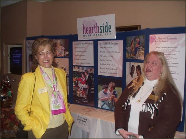 Two people standing in front of an informational display board at an event.
