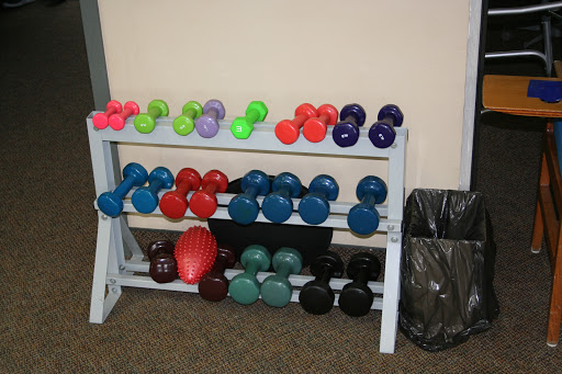 A variety of colorful dumbbells organized on a rack, ready for workout sessions.