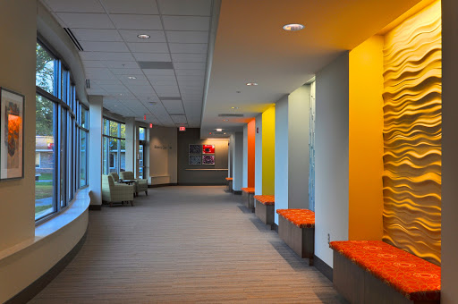 A vibrant and modern hallway featuring colorful walls and a comfortable sitting area.