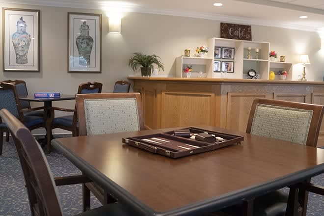A cozy indoor setting featuring a table and chairs, with a coffee bar in the background.