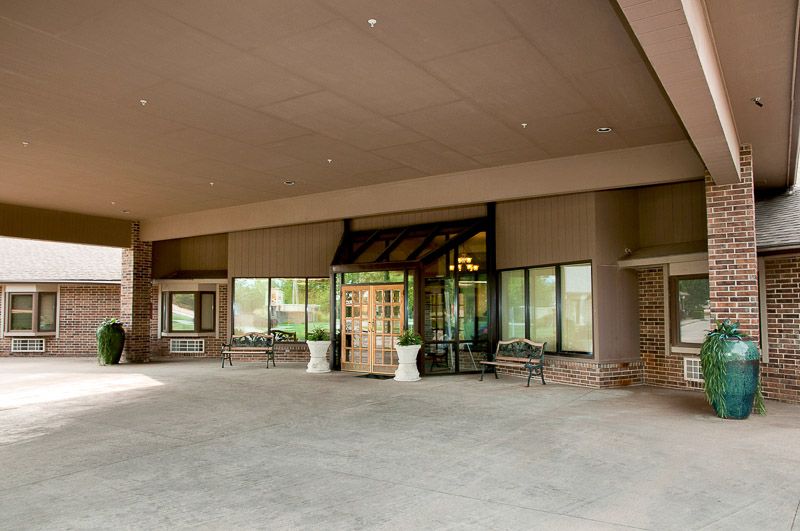 The main entrance of a building with glass doors and large windows.