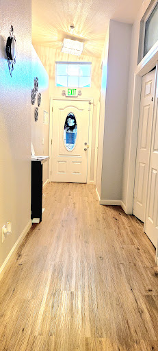 A well-lit hallway featuring a stylish front door and polished flooring.