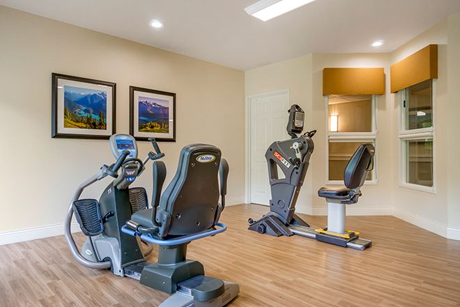 A modern gym with exercise equipment, including recumbent bikes.