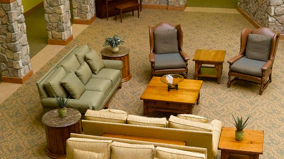 A cozy living room with sofas, a chair, and wooden coffee tables.