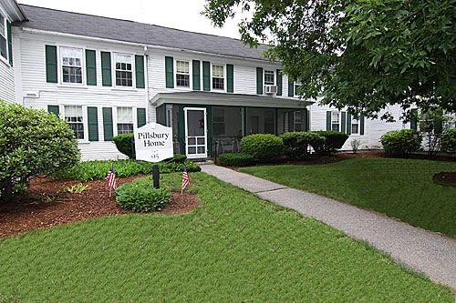 A two-story residential house with a front lawn and pathway leading to the entrance.