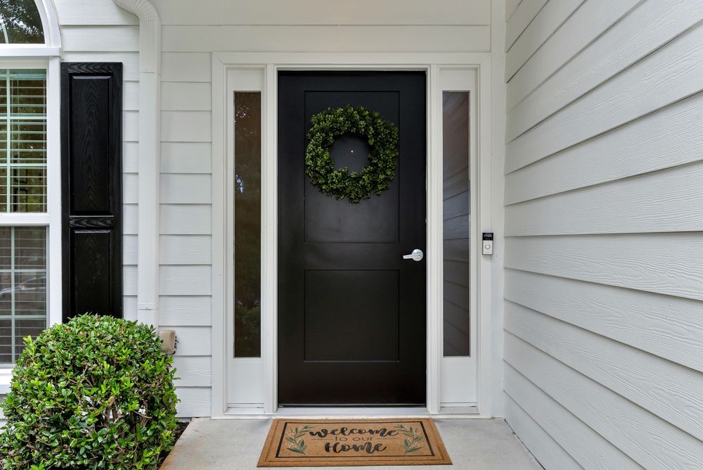A welcoming front door adorned with a wreath and a 'Home Sweet Home' doormat.