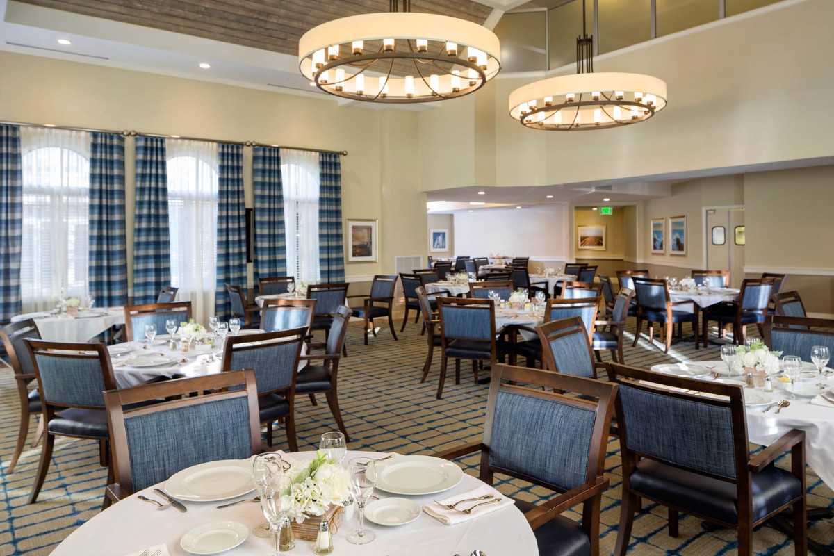 A well-appointed dining area with elegant chandeliers and neatly arranged tables.