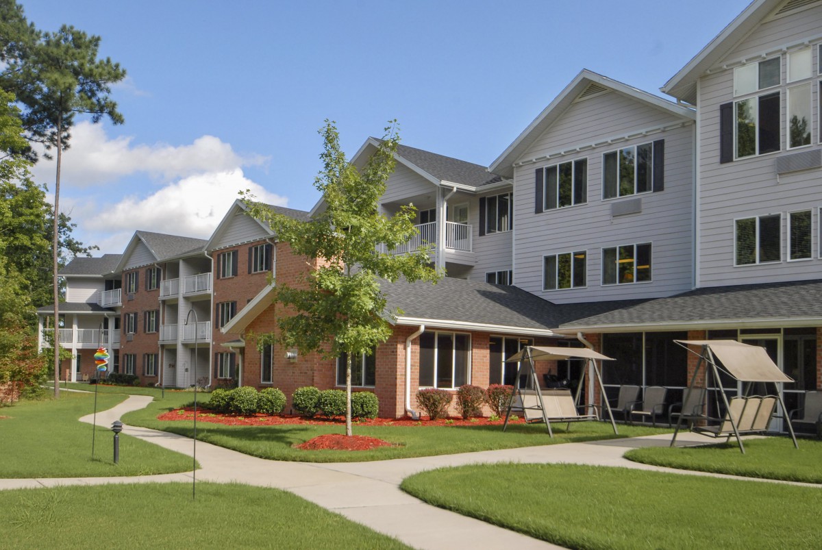 A residential apartment complex with landscaped lawns and pathways.