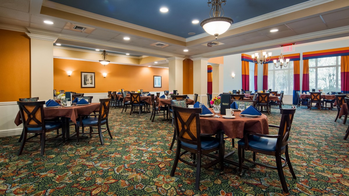 A spacious dining area with elegantly set tables and warm lighting.