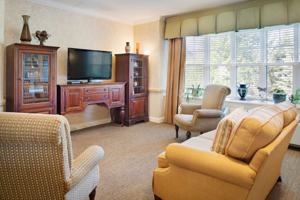 A cozy living room with classic furniture and a large window letting in natural light.