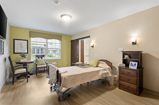 A well-lit hospital room featuring a single bed and comfortable furnishings.