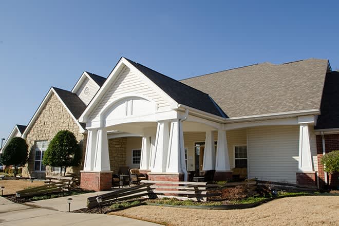 A suburban residential house with a front porch and well-maintained yard.