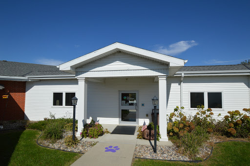 A bright and inviting white building with a well-maintained entrance and landscaping.