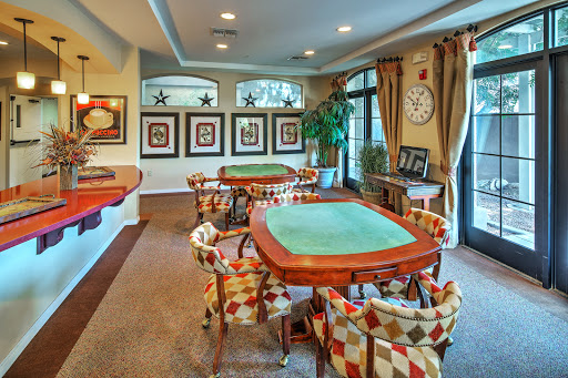 A cozy and stylish game room featuring poker tables and comfortable seating.