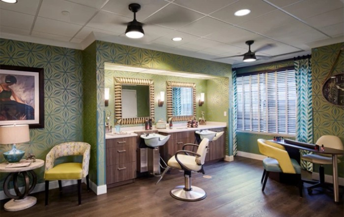 A modern beauty salon interior with stylish chairs and illuminated mirrors.