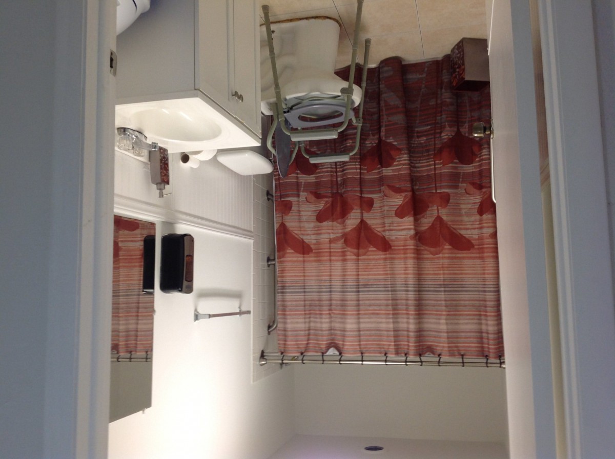 A minimalist bathroom featuring a sink, mirror, and patterned curtain.