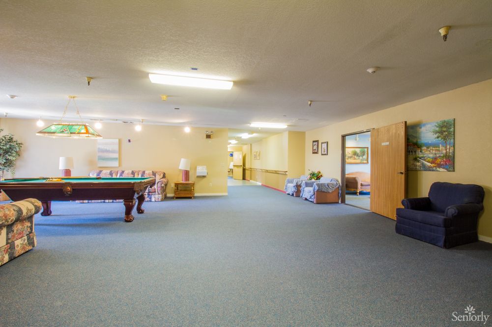 A spacious recreational room featuring a pool table and comfortable seating areas.